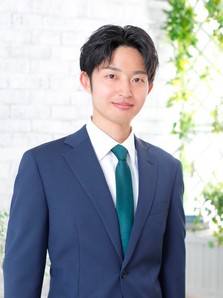 印象改善後の男性の写真（明るい背景・青スーツ）