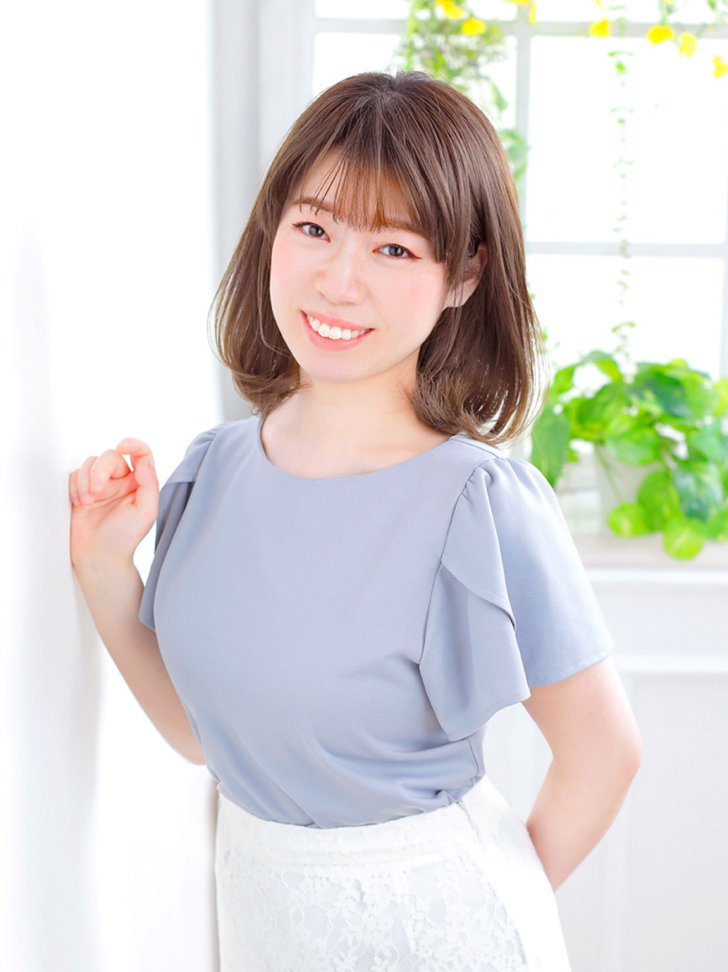 印象改善後の女性の写真（笑顔・パステルカラーの服）