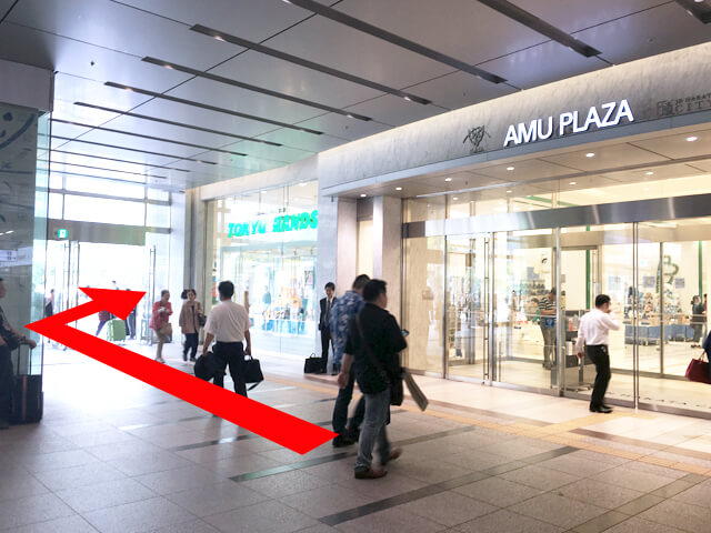 右手に「AMUPLAZA」が右手に見えてきます。その先を外に出て右に曲がってください。